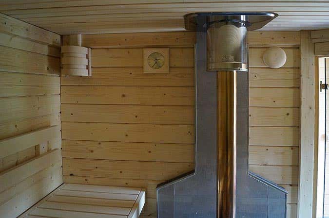 Holzofen in der Sauna, geflieste Hinterwand