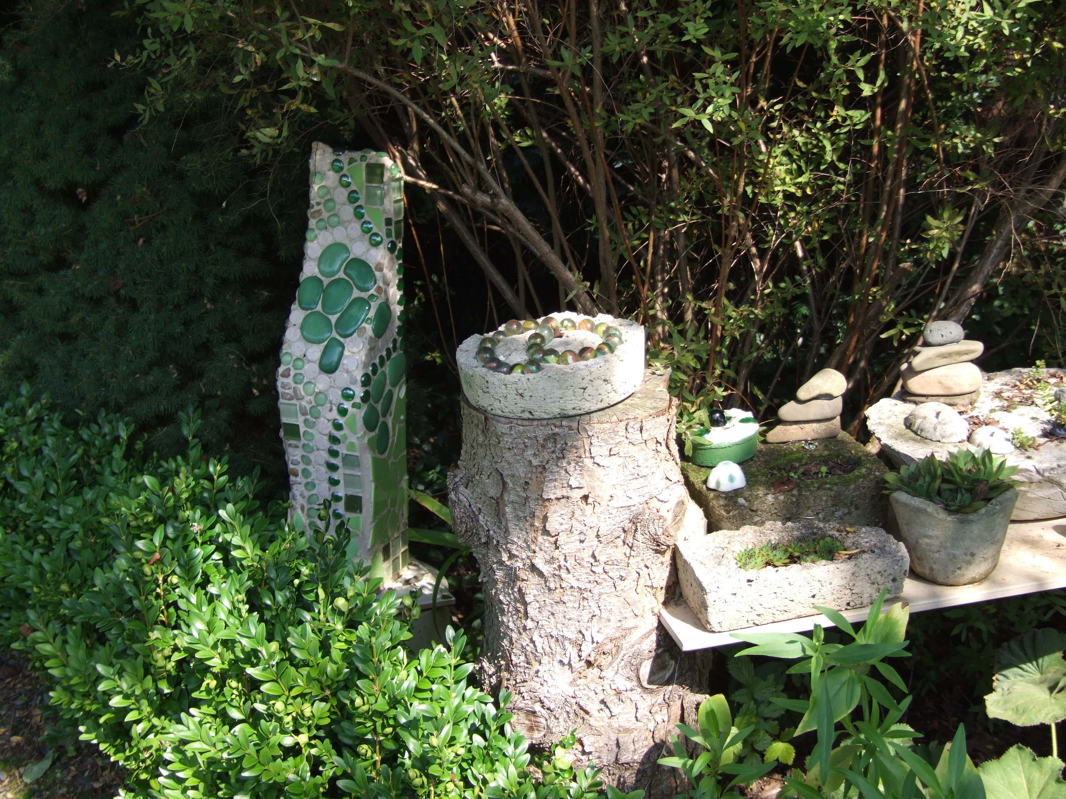 Grün an Grün: Die Mosaik- und Betondekorationen fügt sich perfekt in den Garten ein.