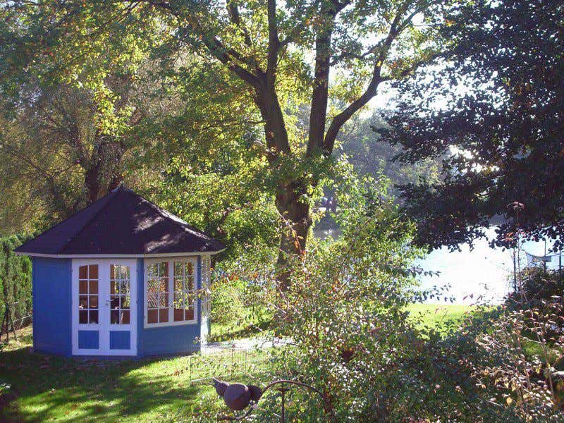 Wirklich malerisch: Das kleine Gartenpavillon unter dem großen, starken Baum.