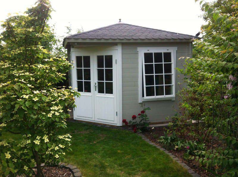 Verschönert die Grenze zum Nachbargrundstück: das Gartenhaus-Modell Monica-28 in grau-weiß. Damit das auch Ihr Nachbar findet: lesen Sie unsere Tipps zur Grenzbepflanzung. 