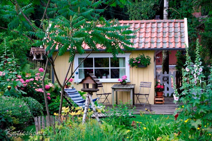 Die gelbe Schwedenhütte am Gartenteich.