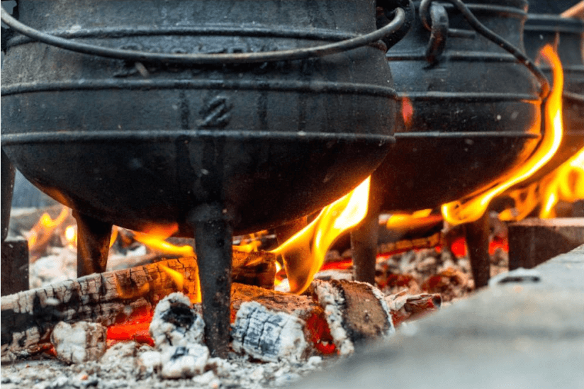 Kochen im gusseisernen Kessel über dem offenen Feuer