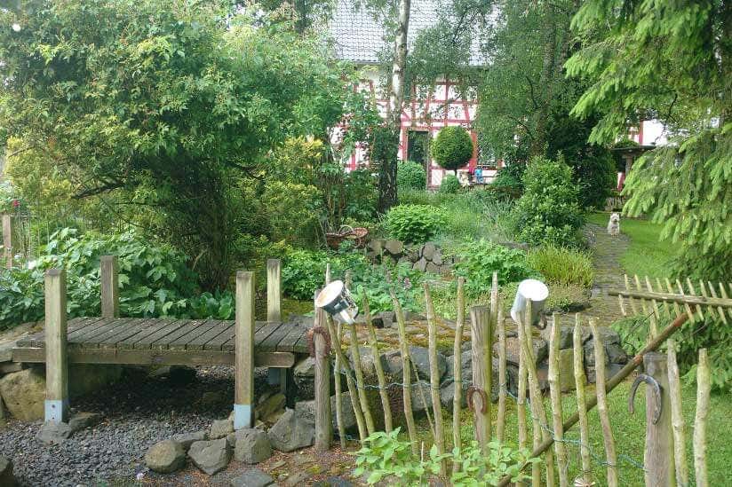 Garten mit Holzbrücke und Zaun
