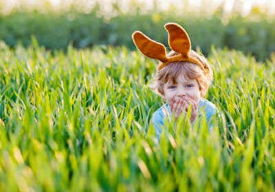 Kind mit Hasenohren im Gras