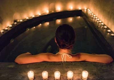 Frau entspannt im Wasser mit Kerzen